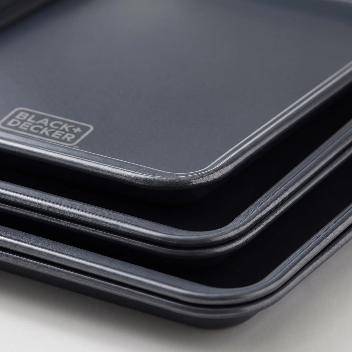 Close-up of the rolled rim and ceramic nonstick surface of a BLACK+DECKER carbon steel baking sheet