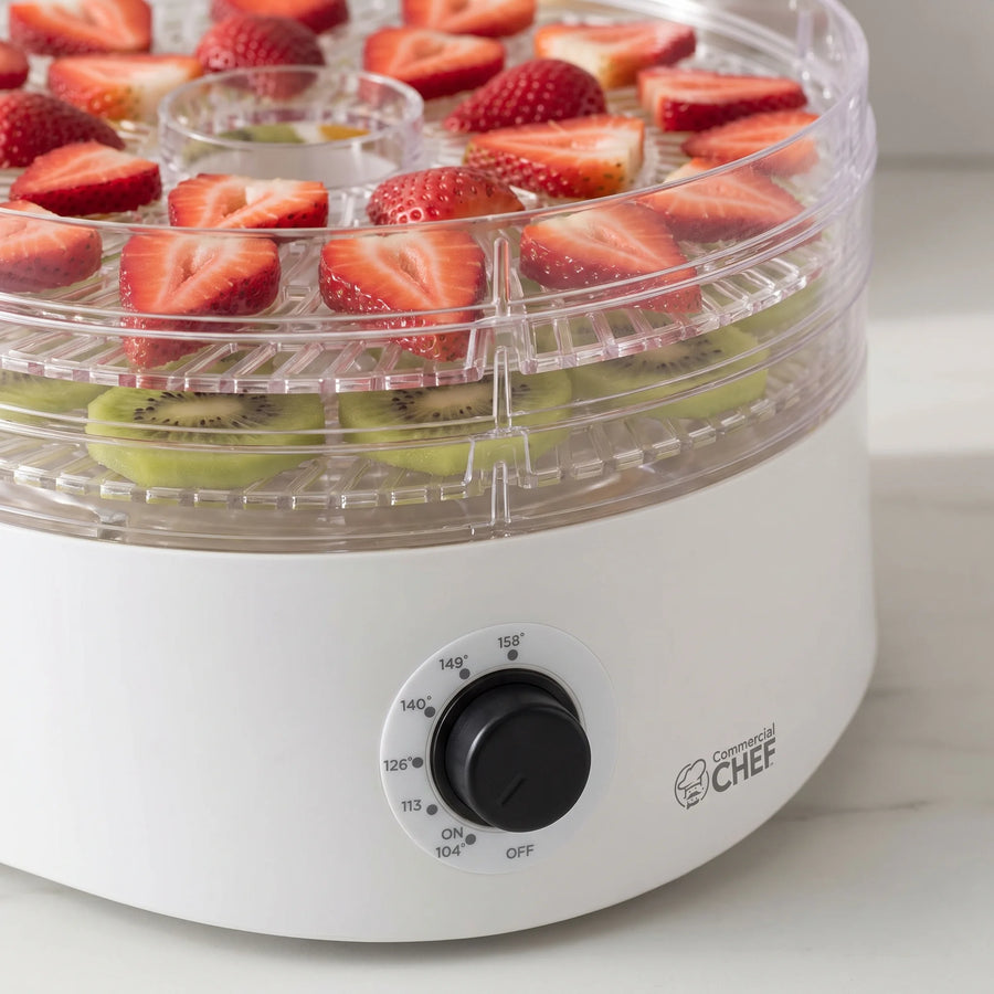 Close-up of the temperature dial and stacked clear trays of fruit on a Commercial Chef 5-tray food dehydrator