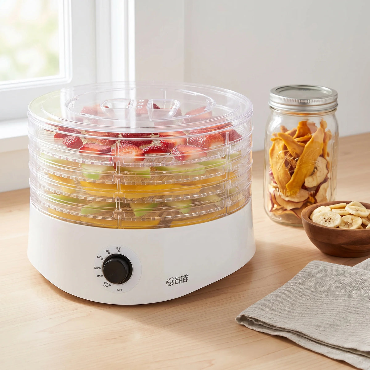 Commercial Chef 5-tray food dehydrator on a counter beside a jar of dried mango and apple chips