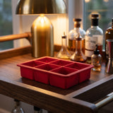 Red Houdini silicone ice cube tray on a home bar cart for cocktails and whiskey