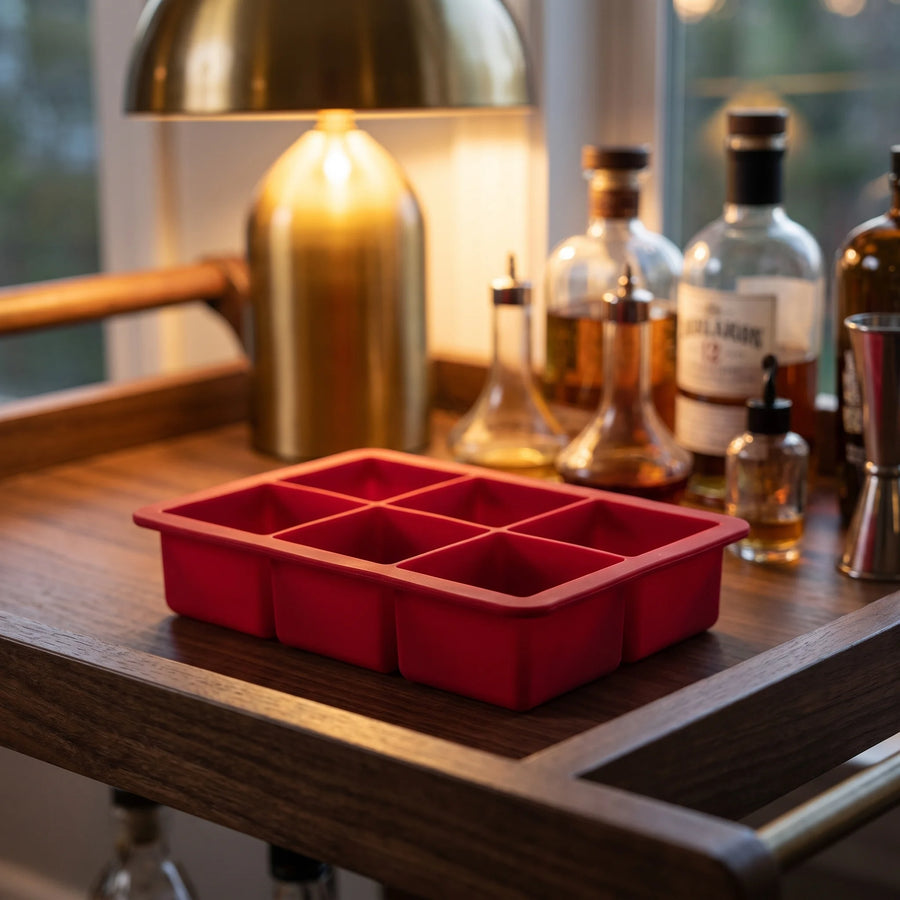 Red Houdini silicone ice cube tray on a home bar cart for cocktails and whiskey