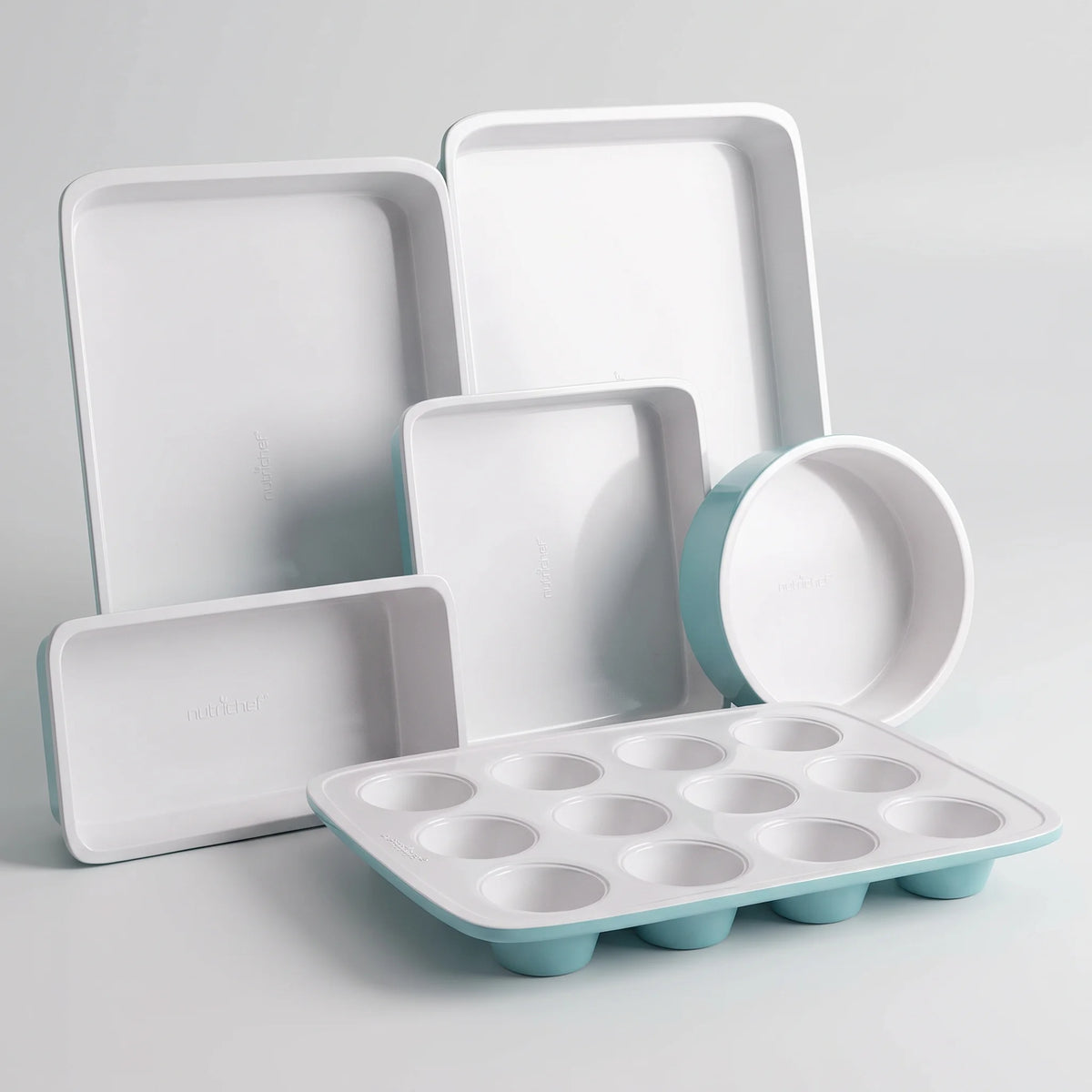 NutriChef 6-piece turquoise and white nonstick bakeware set with cookie sheet, muffin, loaf, round and square pans on a studio surface