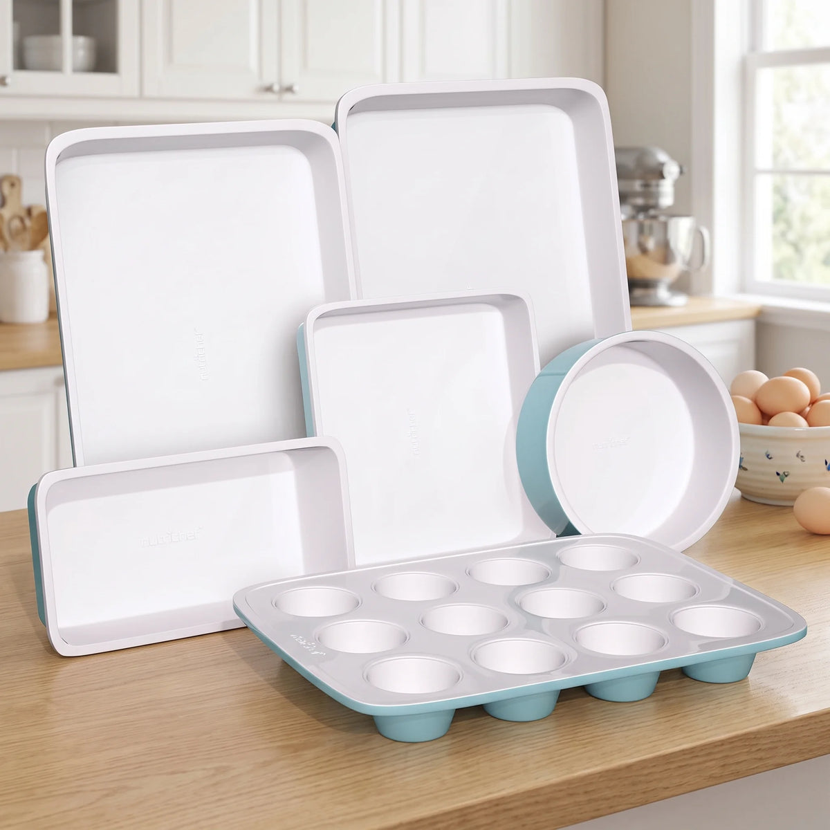 NutriChef 6-piece turquoise and white nonstick bakeware set arranged on a bright kitchen counter ready for baking