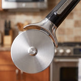 Close-up of the stainless steel cutting wheel, hub and finger guard of a Farberware professional pizza cutter