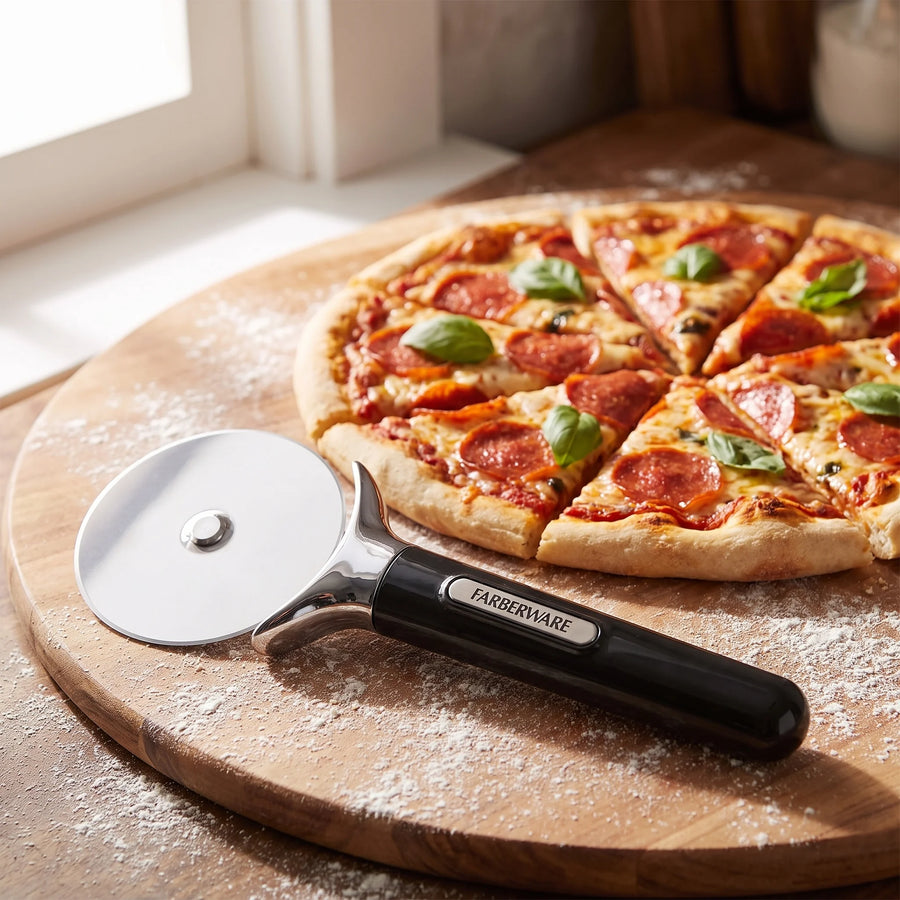 Farberware stainless steel pizza cutter on a wood board beside a freshly sliced pepperoni pizza