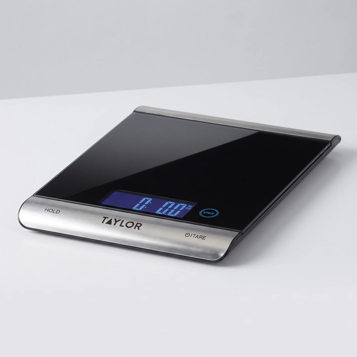 Taylor 3851 digital kitchen scale with black tempered glass platform and blue backlit display on a studio surface