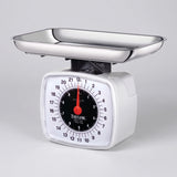 Taylor 3880 analog kitchen food scale with white housing, large dial and stainless steel tray on a studio surface