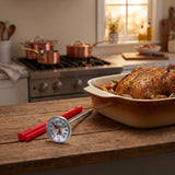 Taylor instant read dial thermometer on a kitchen counter beside a roasting pan at Sunday dinner