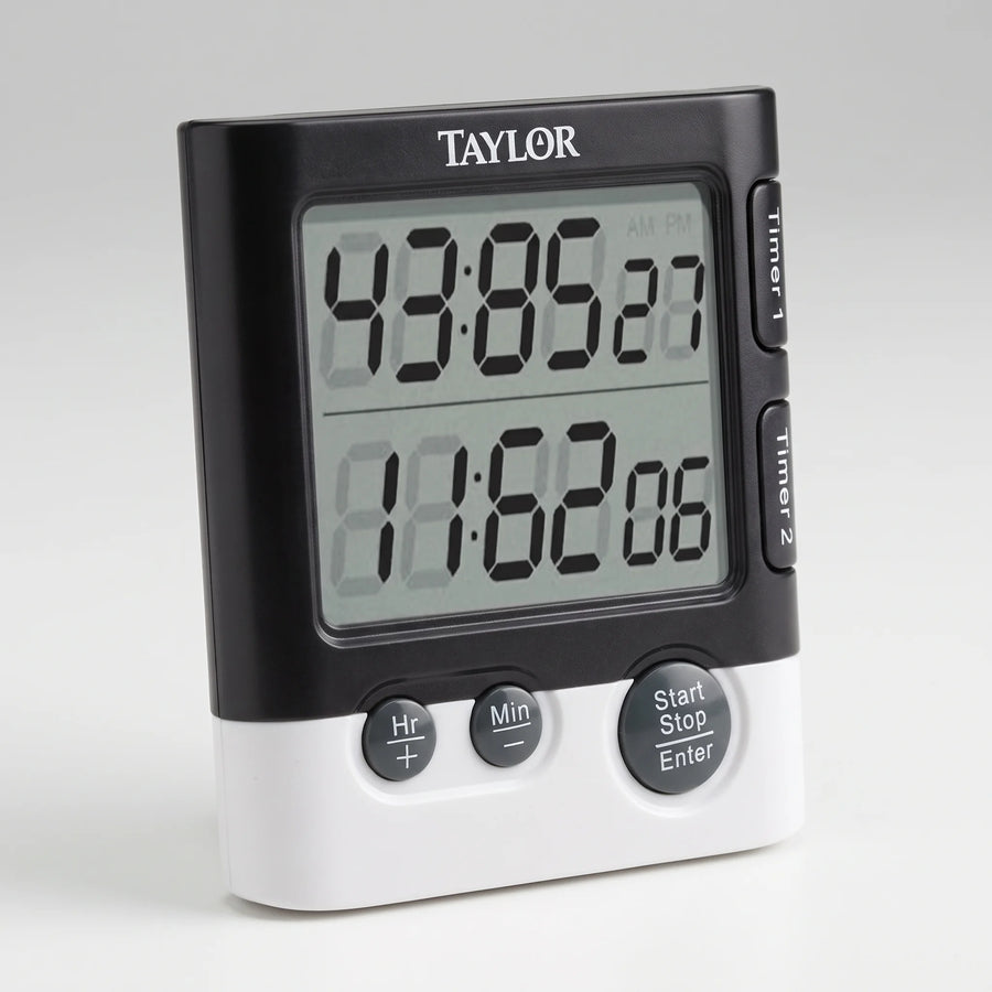 Taylor dual event digital kitchen timer with two large LCD readouts and Timer 1 and Timer 2 buttons on a studio surface