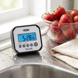 Taylor splash and drop water resistant timer on a sink-side counter with water droplets and a bowl of strawberries