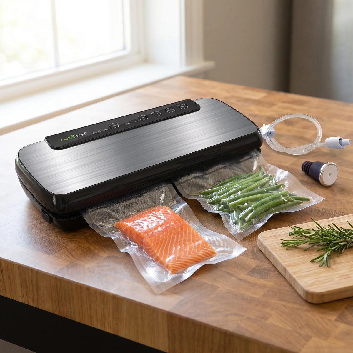 NutriChef vacuum sealer on a counter beside vacuum-sealed salmon and green bean bags for meal prep