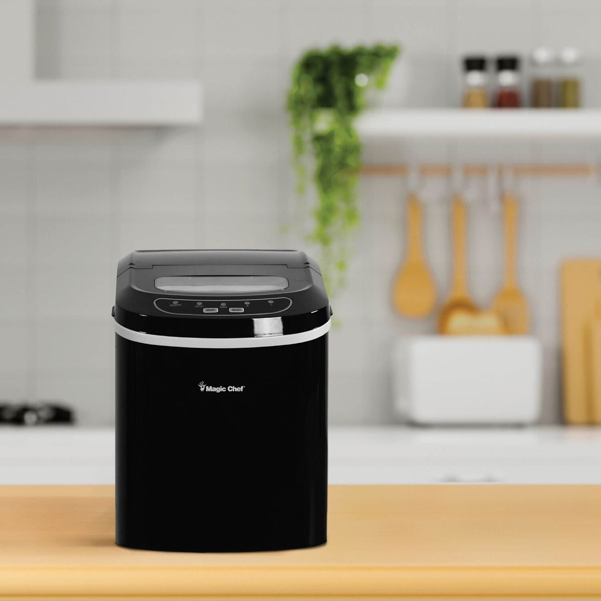 Black Magic Chef portable countertop ice maker on a kitchen counter with wooden utensils behind it