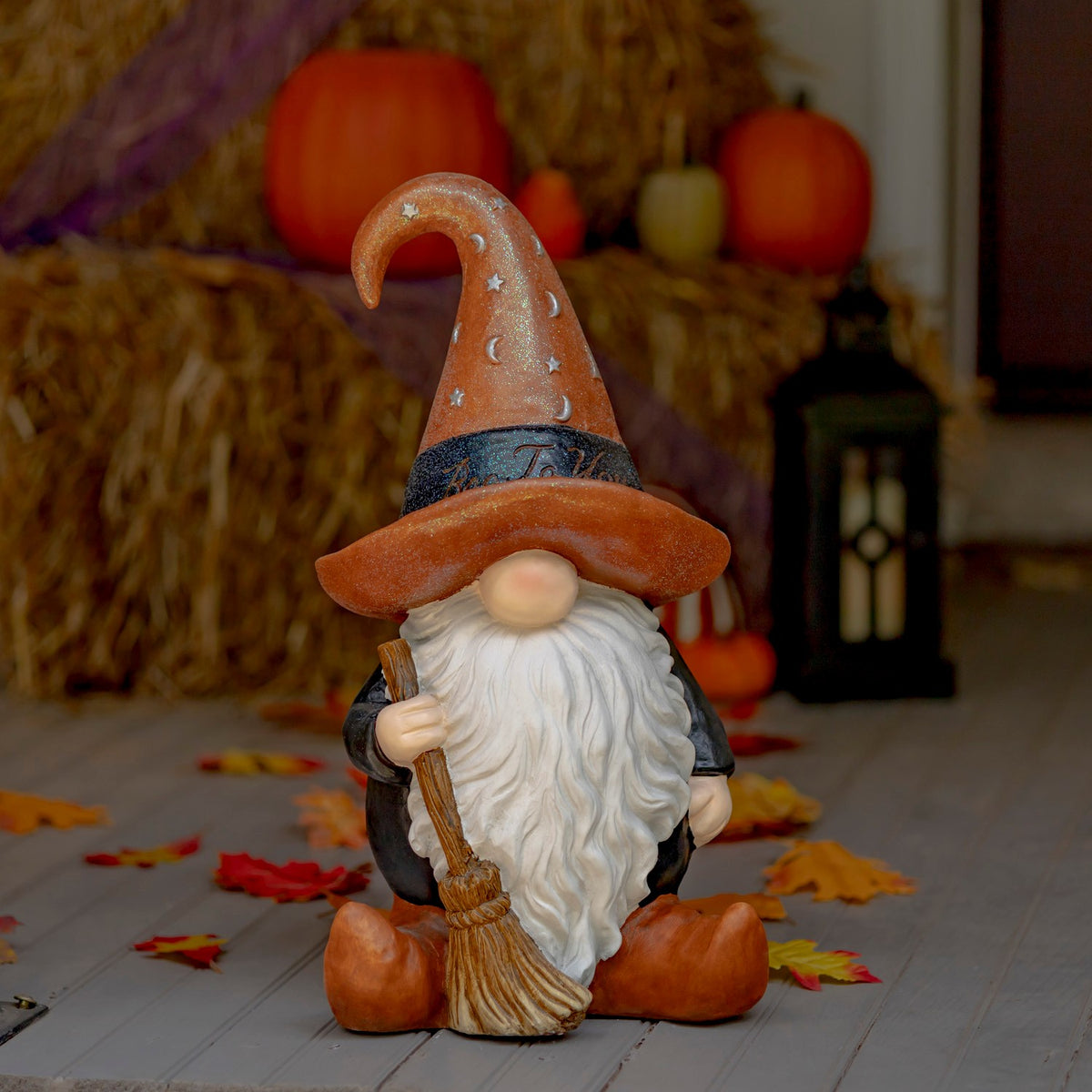 Hand painted Halloween garden gnome warlock in a brown hat holding a broom