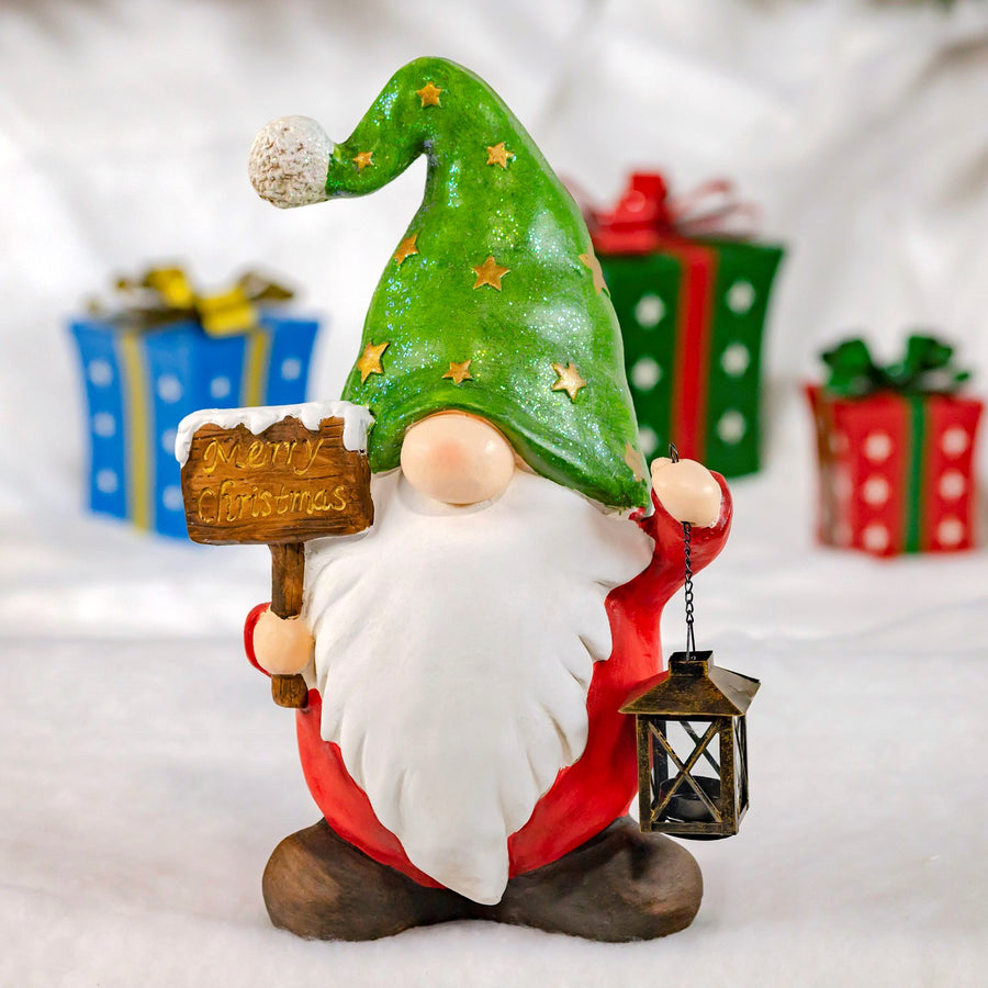 Christmas garden gnome holding a wooden sign and a lantern, wearing a tall green star hat and a white beard