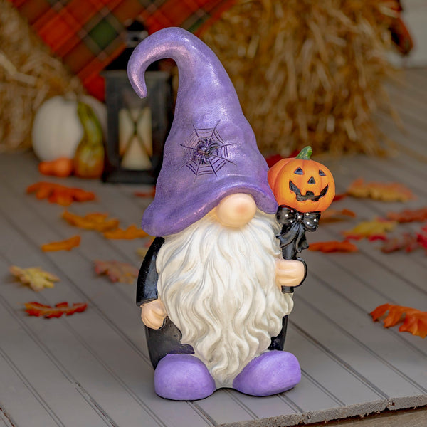 Hand painted Halloween garden gnome wizard in a purple hat holding a pumpkin topped wand
