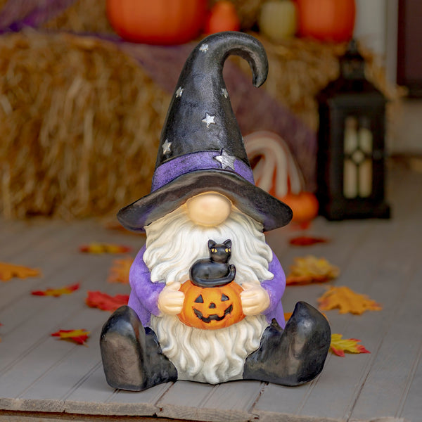 Hand painted Halloween garden gnome witch holding a jack-o-lantern with a small kitten